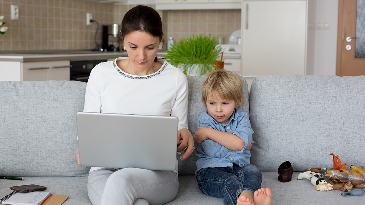 Donna al computer portatile con un bambino piccolo